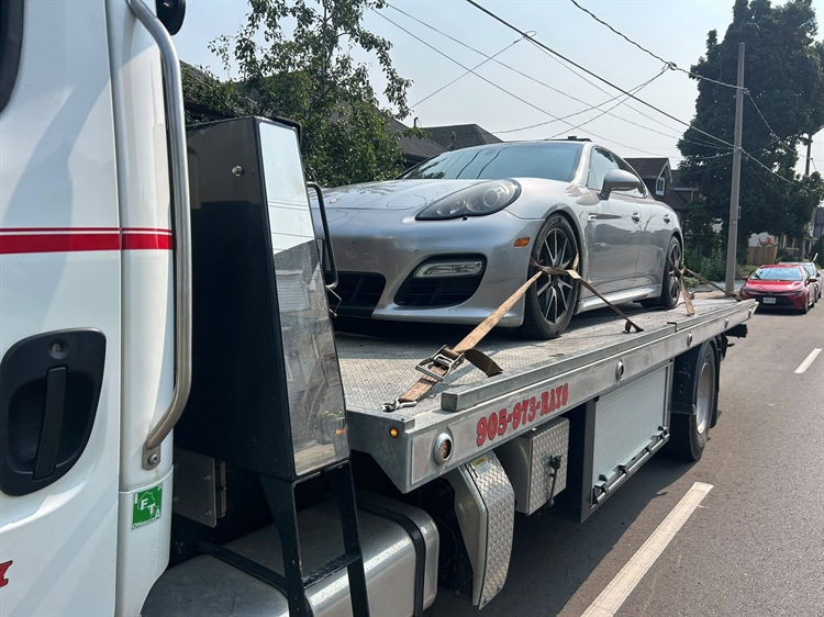 Flatbed tow truck carrying a car